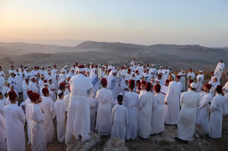 Samaritans in white robes praying on Mount Gerizim at dawn